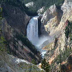 distant waterfall surrounded by rocks and trees